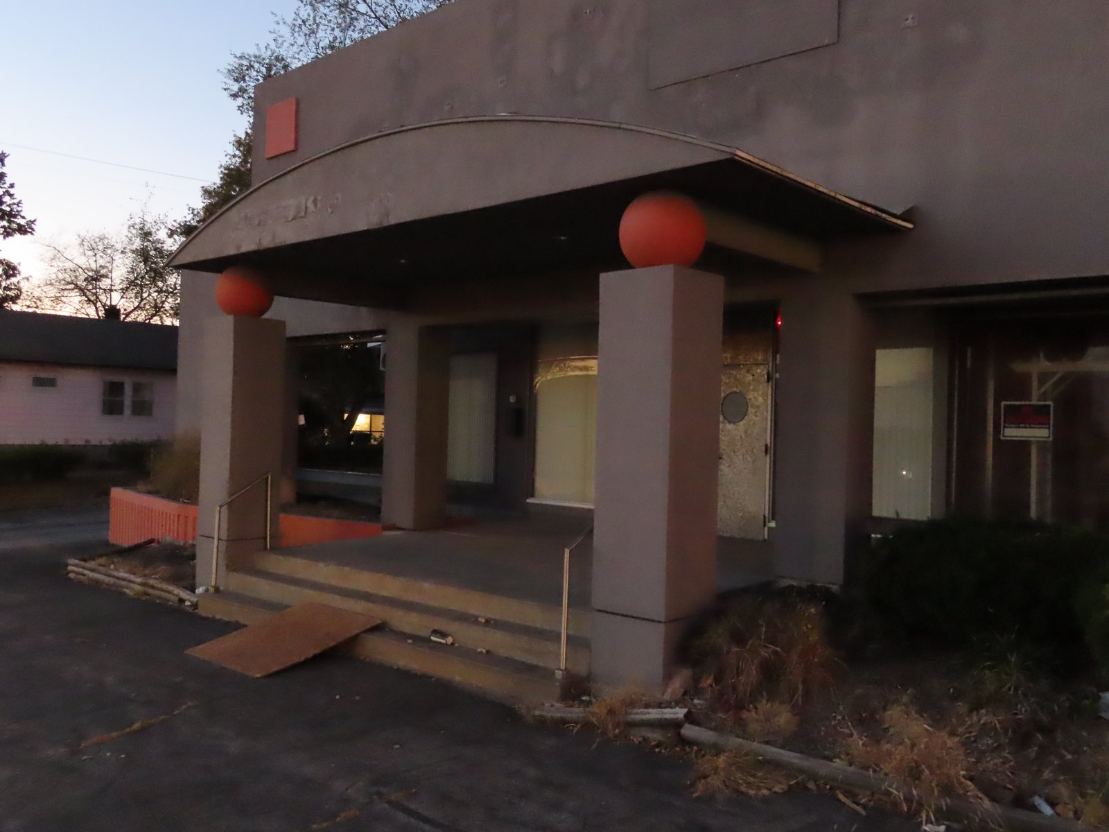 Front entrance. Gray angular pillars topped with pink spheres.